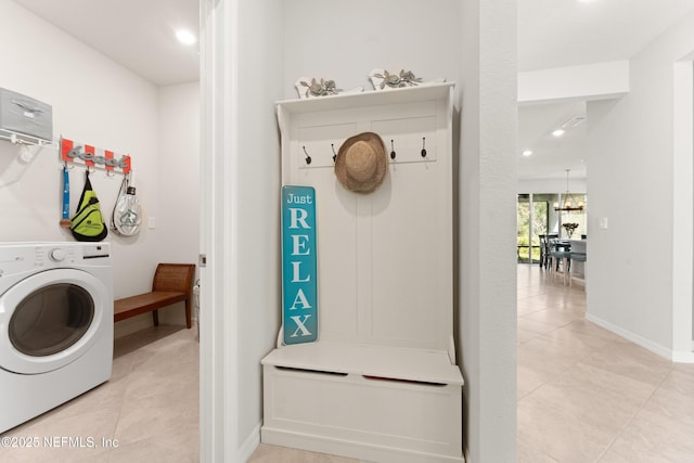 clothes washing area featuring washer / clothes dryer, light tile patterned floors, baseboards, and laundry area