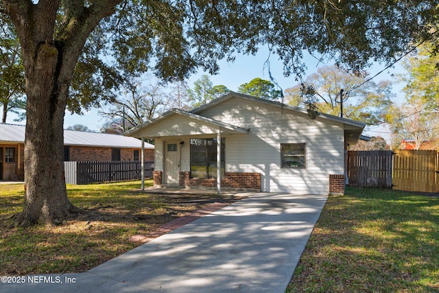 view of front of house featuring brick siding, fence, and a front lawn