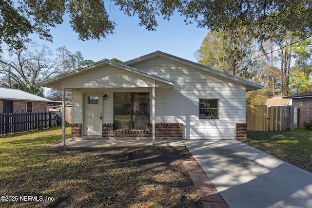 view of front of house featuring brick siding, a front yard, and fence