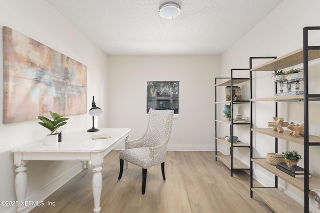 office area featuring a textured ceiling, baseboards, and wood finished floors