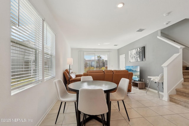 dining area featuring baseboards, stairs, visible vents, and light tile patterned flooring