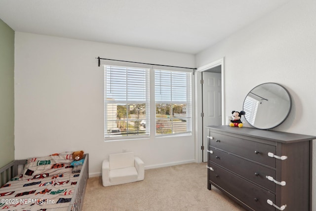 bedroom featuring light colored carpet and baseboards