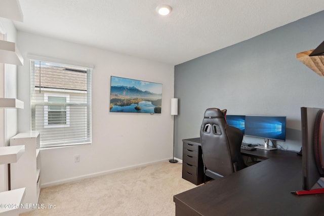 office area with light carpet, a textured ceiling, and baseboards