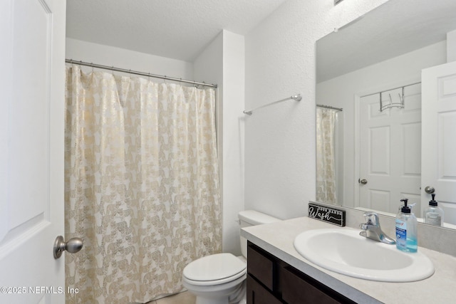 full bathroom featuring vanity, toilet, and a textured ceiling