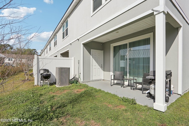 exterior space featuring a patio area, central AC, a yard, and stucco siding