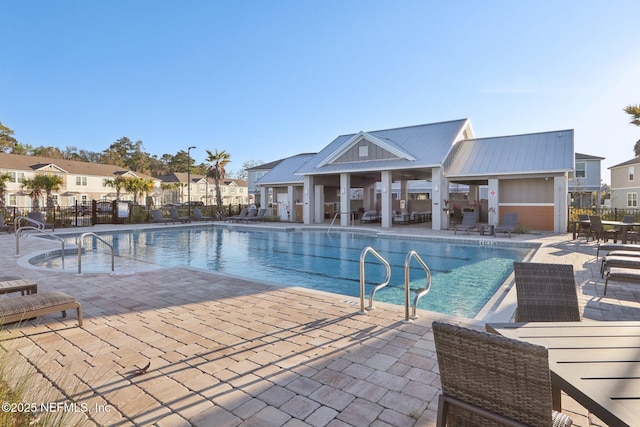 pool with a residential view, fence, and a patio