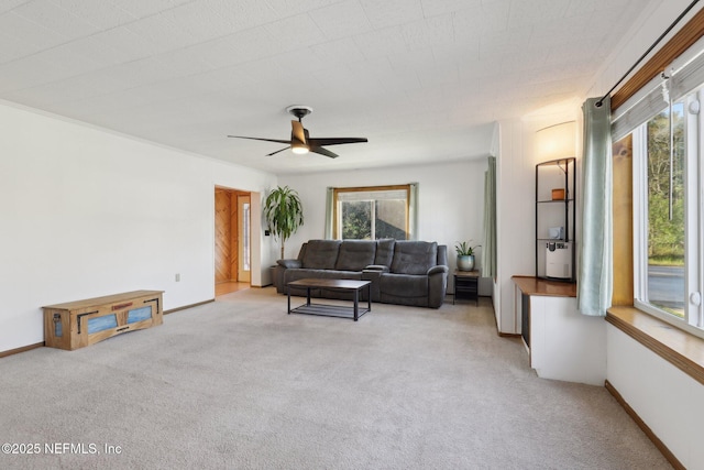 living room featuring ceiling fan, baseboards, and carpet