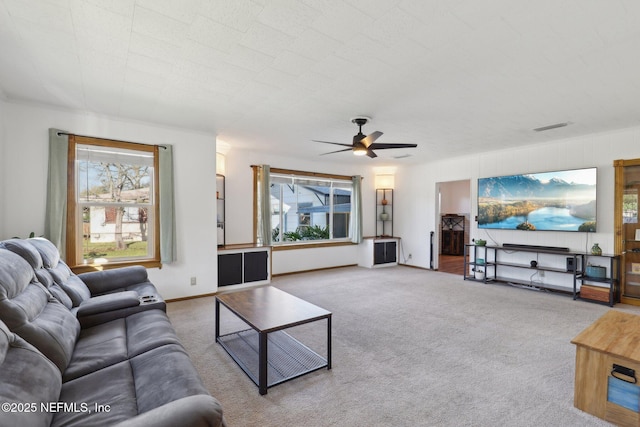 carpeted living area featuring visible vents, baseboards, and a ceiling fan