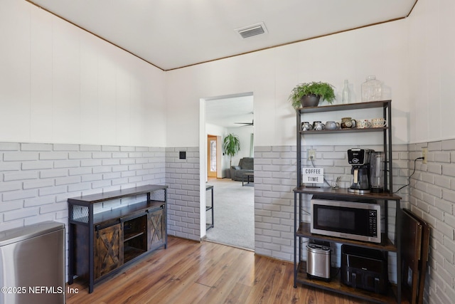 living area with visible vents and wood finished floors