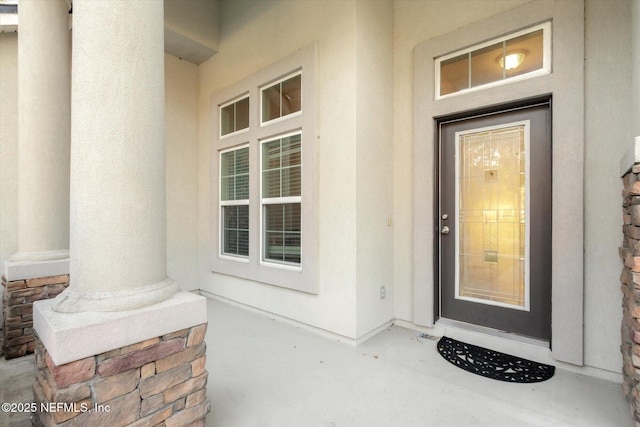 property entrance with stone siding and stucco siding