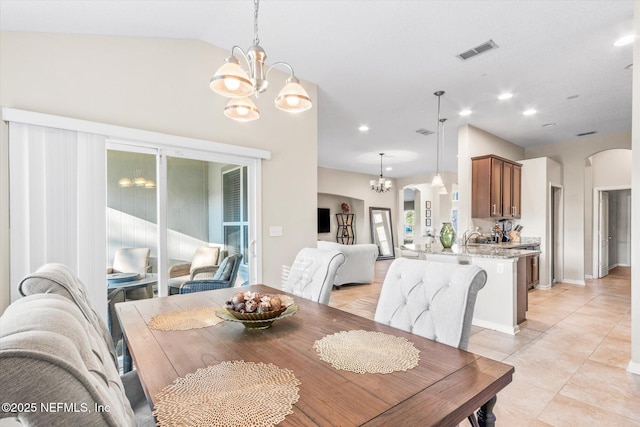 dining room with arched walkways, vaulted ceiling, visible vents, and a notable chandelier