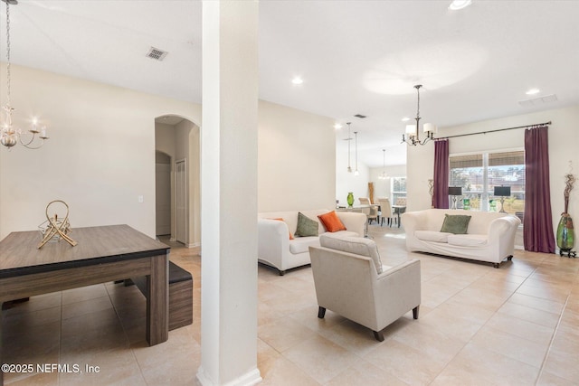 living area with a chandelier, arched walkways, visible vents, and recessed lighting