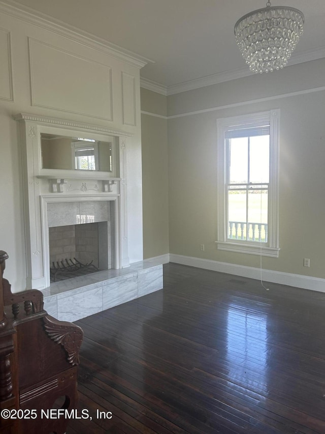 unfurnished living room with a notable chandelier, a premium fireplace, crown molding, and wood finished floors