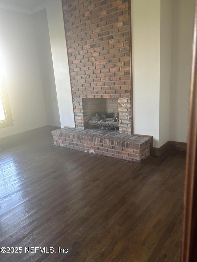 unfurnished living room featuring a fireplace, wood finished floors, and baseboards