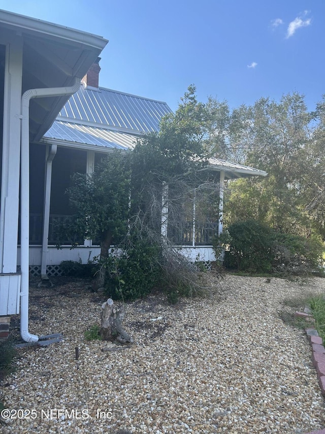 view of home's exterior featuring metal roof and a sunroom