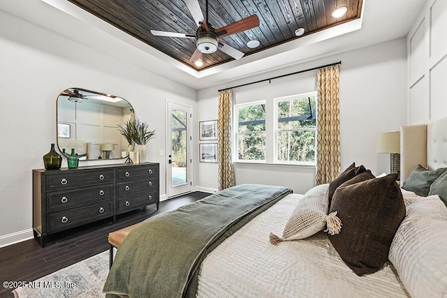 bedroom with dark wood finished floors, a raised ceiling, access to outside, wooden ceiling, and baseboards