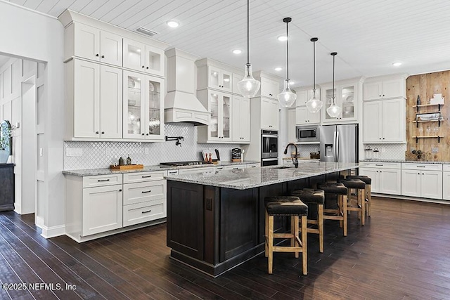 kitchen featuring custom exhaust hood, white cabinetry, appliances with stainless steel finishes, and a sink