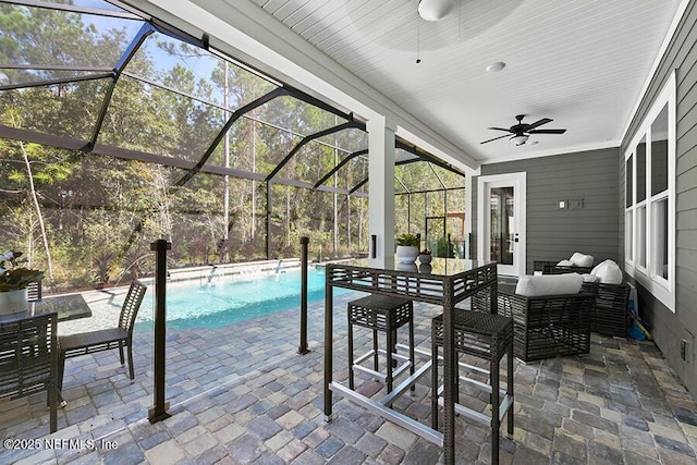 outdoor pool with a ceiling fan, a lanai, outdoor lounge area, and a patio