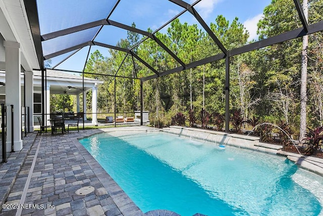 outdoor pool with glass enclosure, ceiling fan, and a patio