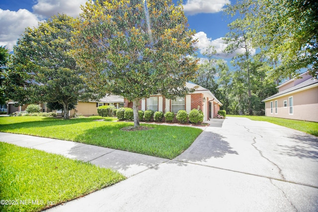 2534 Willow Creek Dr, Fleming Island, FL 32003 - obstructed view of property with driveway, a front lawn, brick siding, and a garage