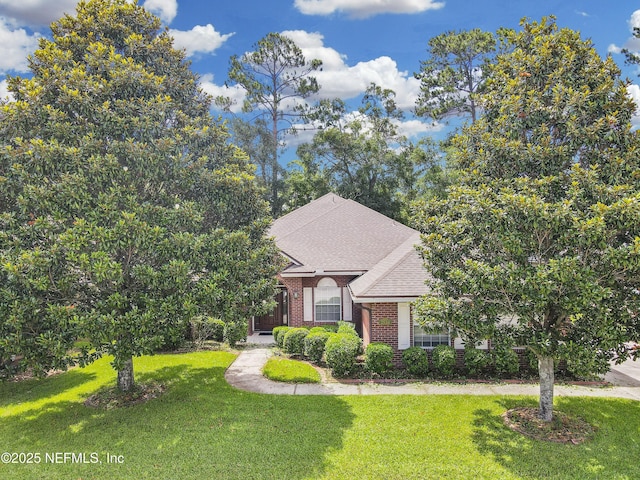 2534 Willow Creek Dr, Fleming Island, FL 32003 - view of property hidden behind natural elements featuring brick siding, a front yard, and a shingled roof