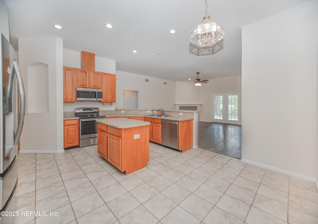 2534 Willow Creek Dr, Fleming Island, FL 32003 - kitchen with stainless steel appliances, light countertops, a peninsula, a kitchen island, and light tile patterned flooring