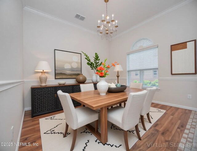 2534 Willow Creek Dr, Fleming Island, FL 32003 - dining room with a chandelier, wood finished floors, and crown molding