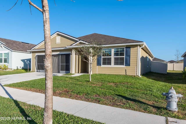 single story home featuring concrete driveway, a front lawn, and an attached garage