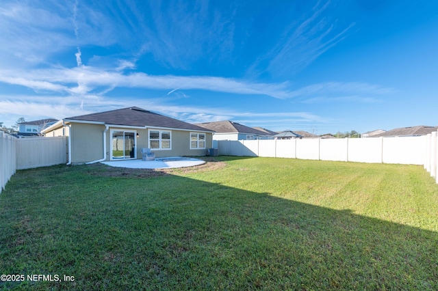 back of property featuring a fenced backyard, a lawn, and a patio