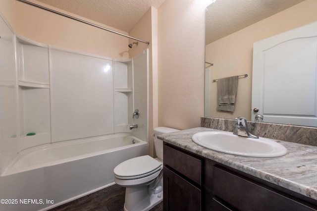 full bath with bathtub / shower combination, toilet, a textured ceiling, vanity, and wood finished floors