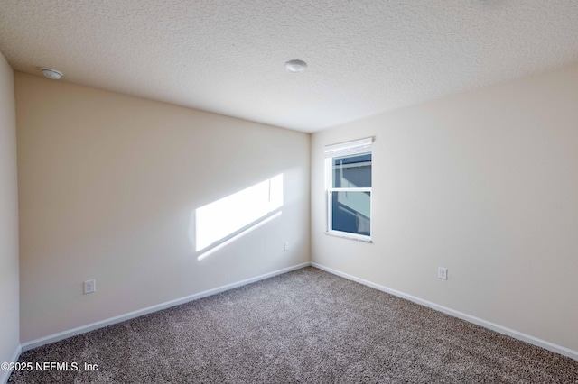 carpeted spare room with baseboards and a textured ceiling