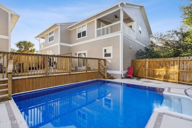 view of swimming pool featuring a fenced in pool, fence, a wooden deck, and a ceiling fan