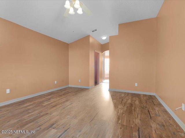 unfurnished room with visible vents, ceiling fan, baseboards, and wood finished floors