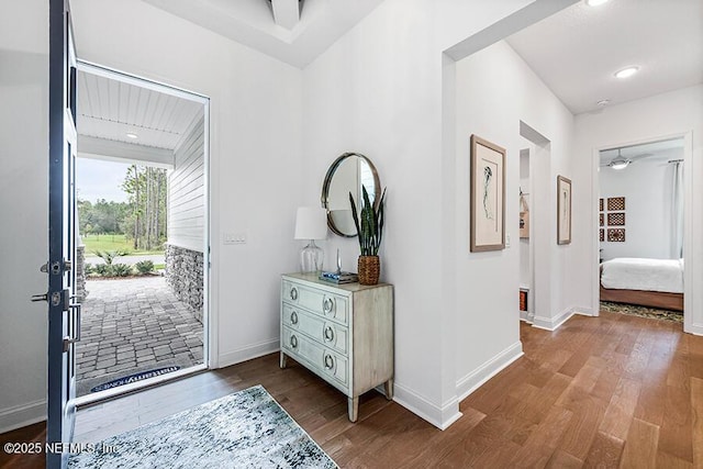 foyer featuring ceiling fan, wood finished floors, and baseboards