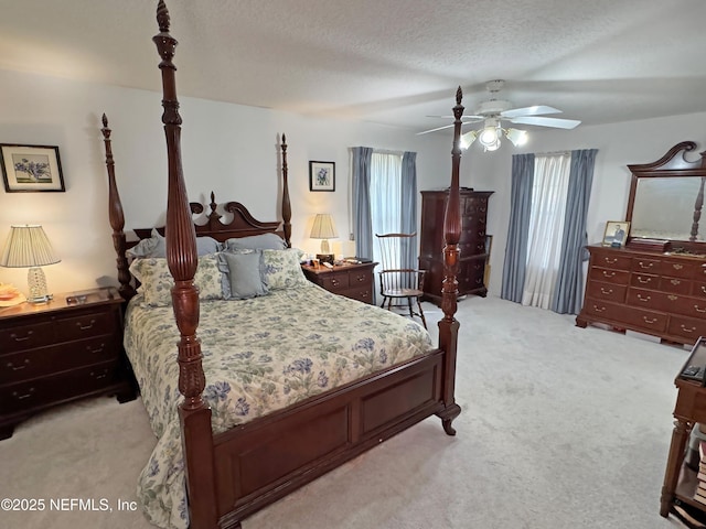 bedroom with a textured ceiling, light carpet, and a ceiling fan