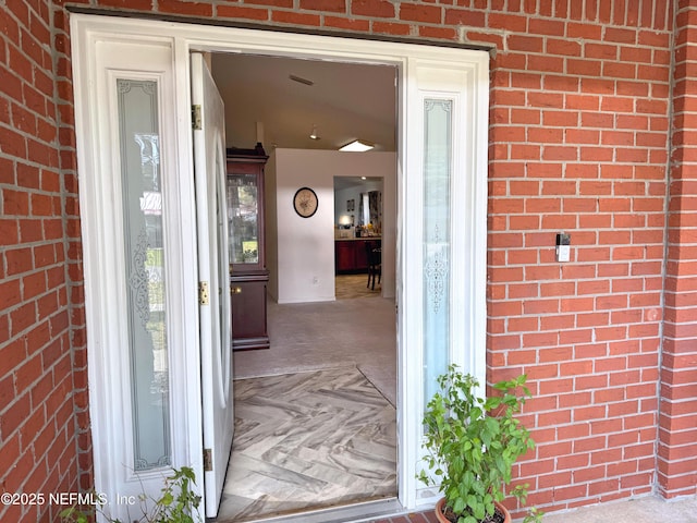 property entrance featuring brick siding