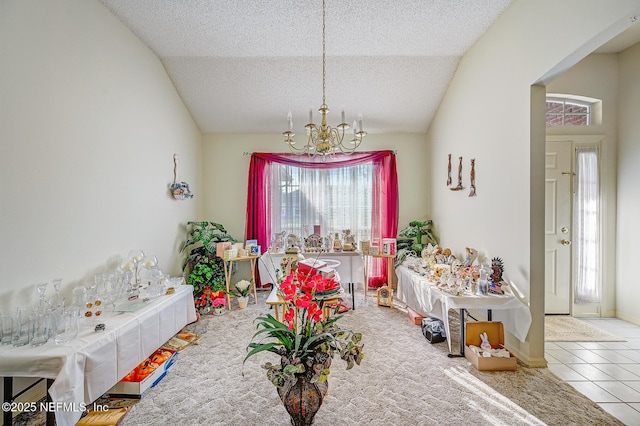 playroom with carpet, an inviting chandelier, vaulted ceiling, a textured ceiling, and tile patterned flooring