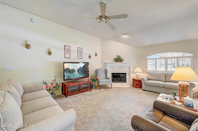 carpeted living area featuring a textured ceiling, ceiling fan, a glass covered fireplace, and lofted ceiling