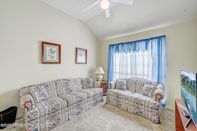 carpeted living area featuring a ceiling fan, lofted ceiling, and a textured ceiling