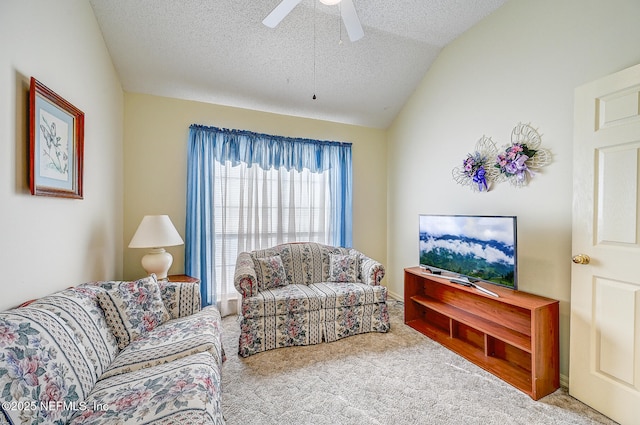 carpeted living room featuring a ceiling fan, vaulted ceiling, and a textured ceiling