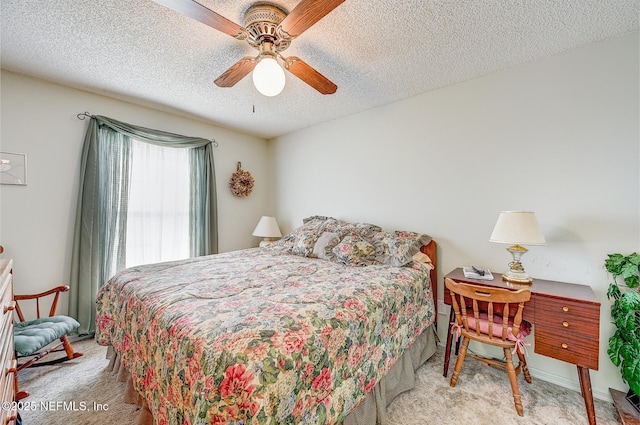 carpeted bedroom featuring ceiling fan and a textured ceiling