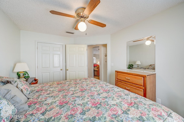 bedroom featuring visible vents, ceiling fan, and a textured ceiling