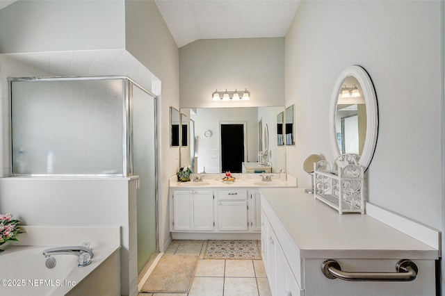 bathroom featuring double vanity, a stall shower, tile patterned flooring, vaulted ceiling, and a bath