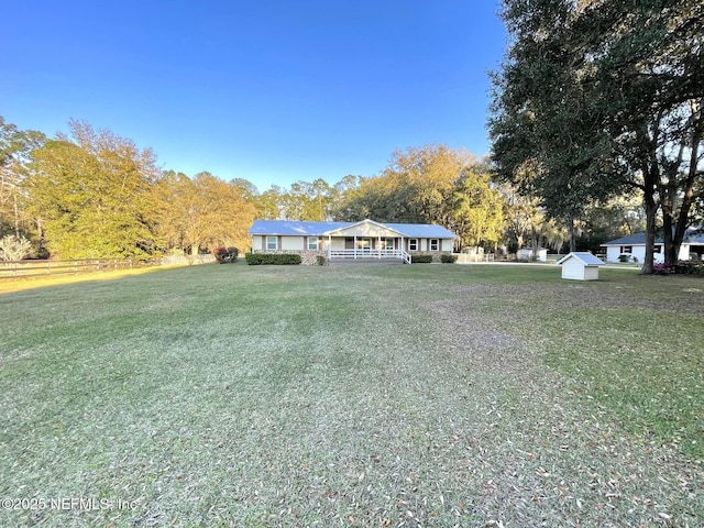 view of front facade featuring an outbuilding, covered porch, a front yard, and a shed