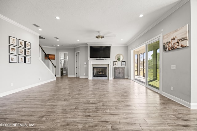 unfurnished living room featuring wood finished floors, a ceiling fan, baseboards, and a textured ceiling