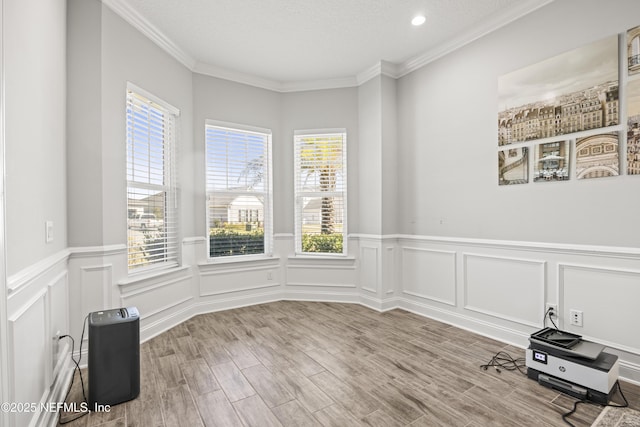 empty room with ornamental molding and wood finished floors