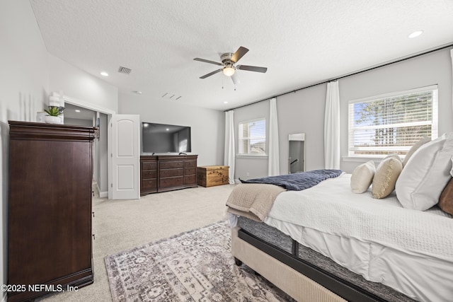 carpeted bedroom featuring recessed lighting, visible vents, a textured ceiling, and ceiling fan