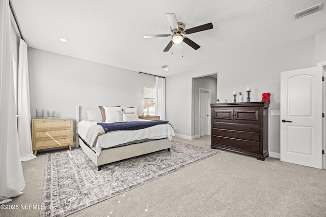 carpeted bedroom with visible vents, baseboards, and a textured ceiling