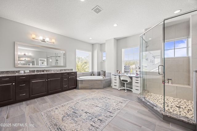 bathroom featuring a stall shower, visible vents, a textured ceiling, and a bath