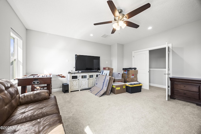 carpeted living area featuring recessed lighting, visible vents, baseboards, and ceiling fan